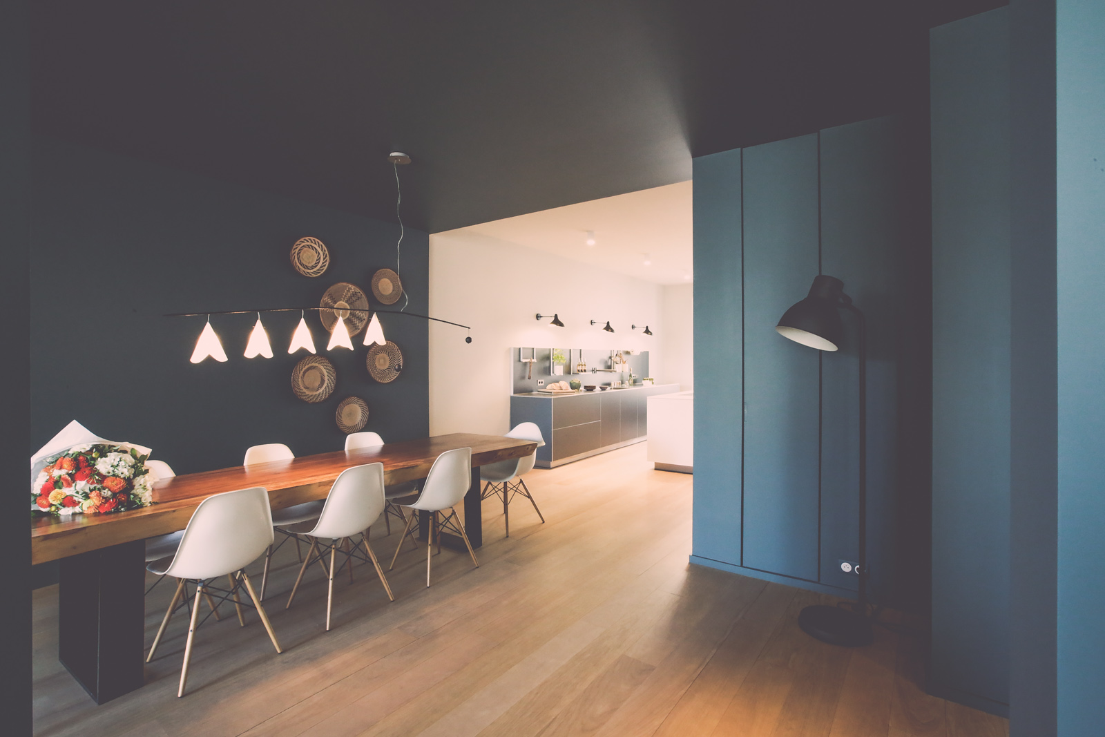 Cuisine bulthaup ouverte sur salle à manger dans un appartement parisien avec table en bois massif et éclairage contemporain